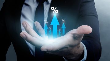 Business hand shows an arrow pointing up with a percentage symbol on his palm. Concept of interest rate, business growth, sales, mortgage, or taxes