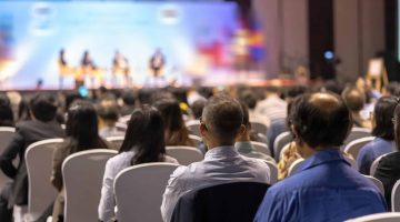 Rear view of Audience listening Speakers on the stage in the conference hall or seminar meeting, business and education about investment concept